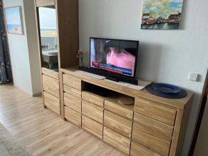 a flat screen tv sitting on top of a wooden entertainment center at Fewo Möwe - a17809 in Heiligenhafen
