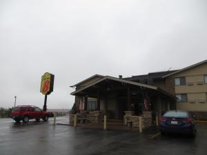 a building with a car parked in a parking lot at Super 8 by Wyndham Spearfish in Spearfish