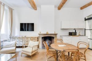 sala de estar con mesa, sillas y chimenea en Maison d' Orange - Ponche en Saint-Tropez