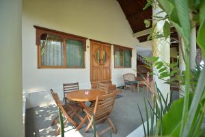 a dining room with a wooden table and chairs at Hibiscus House Pemuteran Bali in Pemuteran