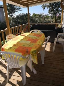 a white table and chairs on a deck with a table and chairs at MOBIL HOME LE MAGNIFIQUE VALRAS PLAGE in Valras-Plage