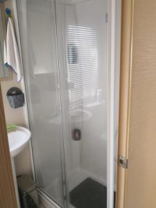 a glass shower in a bathroom with a sink at MOBIL HOME LE MAGNIFIQUE VALRAS PLAGE in Valras-Plage