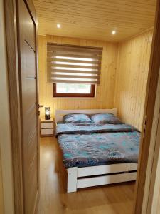 uma cama num pequeno quarto com uma janela em Nocowanie Olga i Oliwia em Okuninka