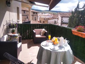 a table on a balcony with a tea set on it at Restaurante & Hotel Rural El Mirador de Trevejo in Villamiel