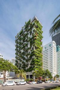 峴港的住宿－Chicland Danang Beach Hotel，一座高大的建筑,旁边是植物