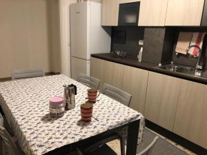 eine Küche mit einem Tisch und eine Küche mit einem Kühlschrank in der Unterkunft Casa Anna in Maiori
