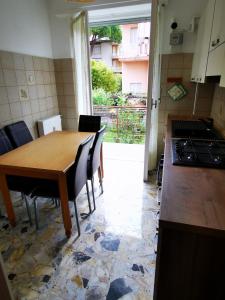 una cucina con tavolo in legno, sedie e piano cottura di Casa Serena a Bordighera