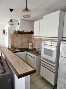 cocina con armarios blancos y encimera en Rez de Villa Climatisé avec Jardin Privatif Domaine des Moulières en La Valette-du-Var