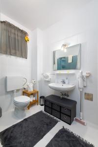 een badkamer met een wastafel, een toilet en een spiegel bij Happy Beach Apartment - Dream on the Beach in Kraljevica