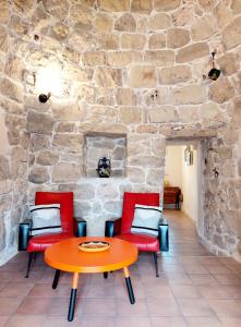 uma mesa e cadeiras num quarto com uma parede de pedra em Trullo di Puglia em Ceglie Messapica