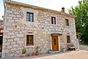 a stone house with a bench in front of it at Boutique Villa Pucinum in Buzet
