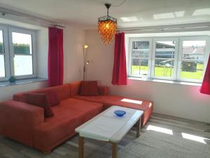 a living room with a red couch and a table at Viel Platz in Bernbach in Bidingen