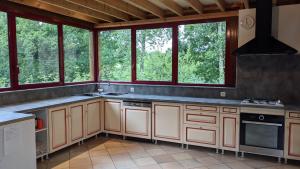 a kitchen with a stove and some windows at L'Angeberdière in Saint-Mars-sur-la-Futaie