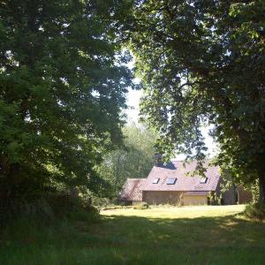 ein Haus auf einem Feld mit Bäumen davor in der Unterkunft L'Angeberdière in Saint-Mars-sur-la-Futaie