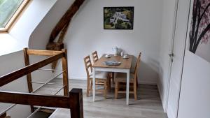 una sala da pranzo con tavolo e sedie di L'Angeberdière a Saint-Mars-sur-la-Futaie