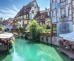 a river in the middle of a city with buildings at Coeur d'Elsass "RAPP"appartement avec parking in Colmar
