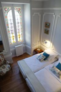 1 dormitorio con cama y vidriera en Maison Eugénie en Luchon