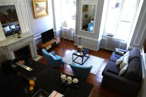 a living room with a couch and chairs and a fireplace at Maison Eugénie in Luchon