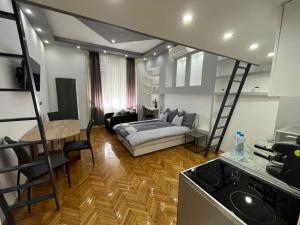 a kitchen and living room with a bed in a room at Széchenyi Apartman (III. Panorama) Miskolc belvárosában in Miskolc