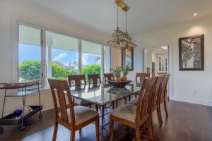 a dining room with a glass table and chairs at Aloha 'Ohana home in Koloa