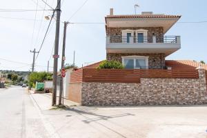 un edificio de ladrillo con balcón en una calle en Franceska's guest house, en Artemida