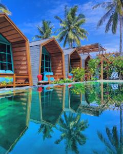 um resort com piscina e palmeiras em Absolute Villa em Gili Trawangan