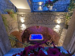 a bathroom with a blue tub in a stone wall at Stone House Hedonia in Blato