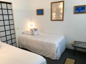a hotel room with two beds and a mirror at Le Windsor, Jungle Art Hotel in Nice