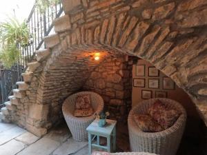 a stone wall with two wicker chairs and a table at Stone House Hedonia in Blato