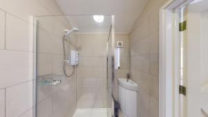 a bathroom with a shower and a toilet at Hidden Jewel Retreat in Budleigh Salterton