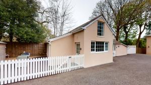a small house with a white picket fence at Hidden Jewel Retreat in Budleigh Salterton