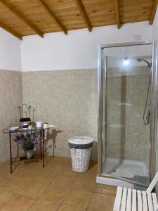 ein Bad mit einer Dusche, einem Tisch und einer Bank in der Unterkunft B&B Domenico Paulis in Tuili