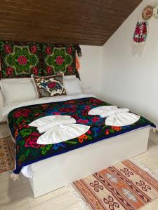 een bed met kussens in een kamer bij Casa Grai Moroșănesc in Breb