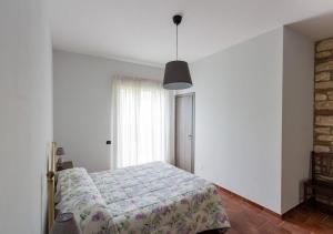 Schlafzimmer mit einem Bett und einem Fenster in der Unterkunft Agriturismo Il Sentiero degli Ulivi - Irpinia in Venticano