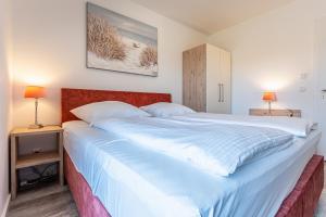 - un grand lit dans une chambre avec 2 tables de nuit dans l'établissement App 20, Strandresidenz Dünenperle, à Kühlungsborn