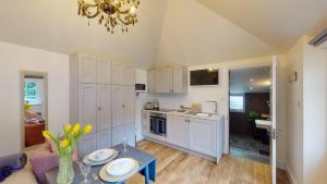 a kitchen with a table and a dining room at Hidden Gem Retreat in Budleigh Salterton