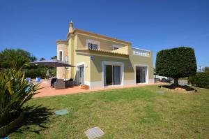 a large yellow house with a yard with a tree at Casa Da Torre Espetacular V4 Com Piscina in Portimão
