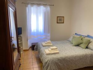 a bedroom with a bed with towels on it at B&B Domenico Paulis in Tuili