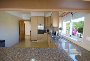 a large kitchen with a sink and a window at Casa Da Torre Espetacular V4 Com Piscina in Portimão