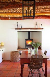 een eetkamer met een tafel en een open haard bij Penhill Farm Peppertree Cottage in Nuy