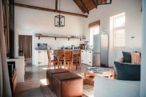 a living room with a table and a kitchen at Penhill Farm Fruit Barn in Nuy