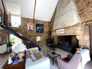 a living room with a large stone fireplace at La maison de Nati in Guidel