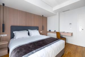 a bedroom with a large bed and a wooden wall at Glyfada Riviera Hotel in Athens