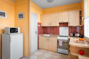 Bartakovics Apartman في إغير: مطبخ بدولاب خشبي وثلاجة بيضاء