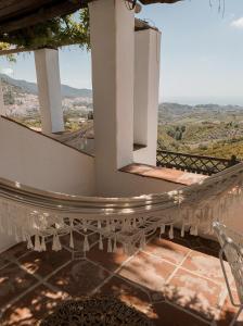 a staircase leading up to a balcony overlooking a city at La Posada Morisca in Frigiliana