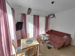 - un salon avec un canapé et une table dans l'établissement Apartament Białowieski, à Hajnówka