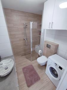 La salle de bains est pourvue d'une douche, de toilettes et d'un lavabo. dans l'établissement Apartament Białowieski, à Hajnówka