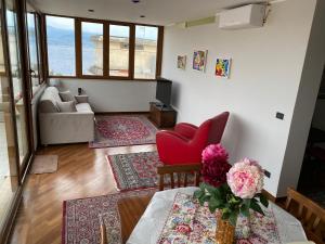 een woonkamer met een tafel en een rode stoel bij Casa MaLù in Messina