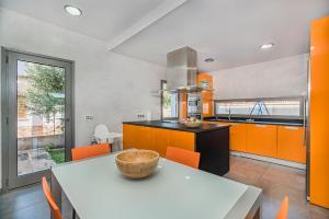 een keuken met oranje kasten en een tafel met een kom erop bij Albufera in Can Picafort