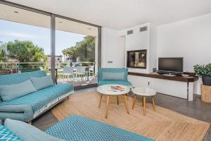 a living room with two blue chairs and a tv at Albufera in Can Picafort